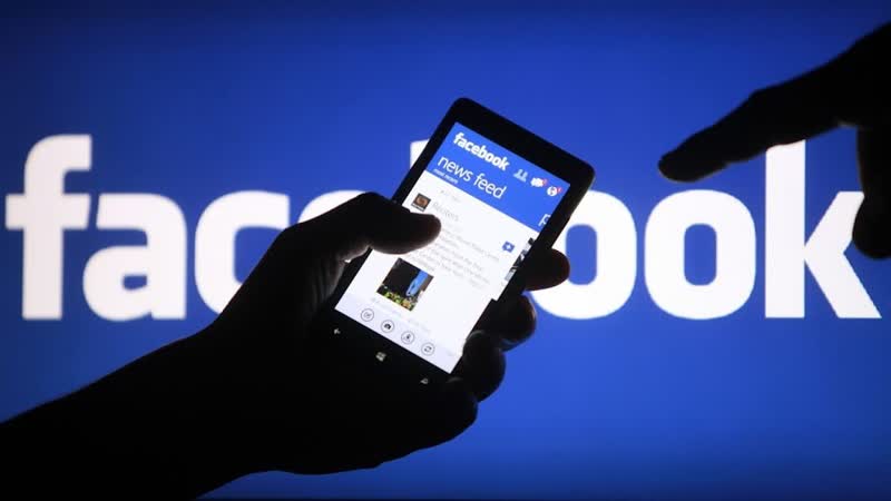 Logo Facebook pada layar ponsel yang sedang dipegang.